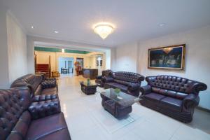 a large living room with leather couches and a table at Noola Inn Hotel Bogor in Kamparganya