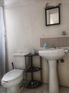 Łazienka z białą toaletą i umywalką w obiekcie Airport Hostel w mieście Ciudad Juárez