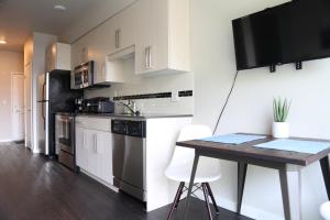 una cocina con armarios blancos y una mesa con sillas. en Queen Anne Abode - 1 Block from CPA! - Free Parking!, en Seattle