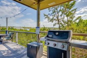 a grill on a deck with a table and a chair at The Outlook - Spa and deck views of Hill Country in Dripping Springs