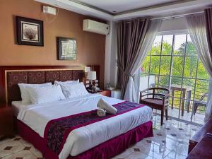 Cette chambre d'hôtel comprend un lit et un balcon. dans l'établissement Marand Resort -Highway, à Bauang