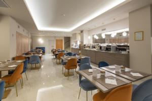 a restaurant with tables and chairs and a kitchen at Hotel Nasco in Milan