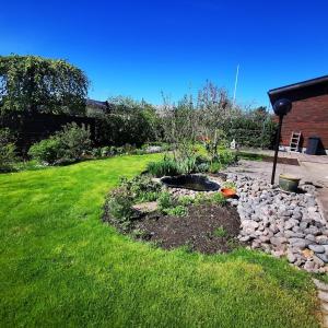 un patio trasero con un jardín con rocas y un patio en Anttoninvahe 7 130m2 with garden and sauna etc, en Rauma