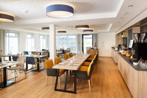 ein Restaurant mit Tischen und Stühlen und einer Theke in der Unterkunft Homey! Hotel in Regensburg