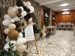 a balloon arch with a sign in a room with a table at Хижа Манастирчето-Книжовник in Haskovo