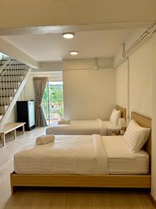 1 dormitorio con 2 camas y escalera en The Ventus Phangan, en Haad Rin