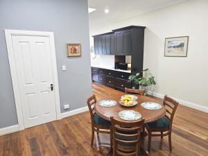 a dining room with a table and chairs and a kitchen at New: Araluen, Heart of Bowral in Bowral