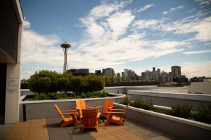 a group of chairs sitting on a balcony with a city skyline at Queen Anne Abode - 1 Block from CPA! - Free Parking! in Seattle