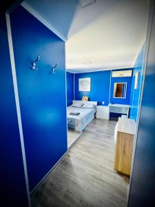 a room with two beds and a blue wall at Хижа Манастирчето-Книжовник in Haskovo