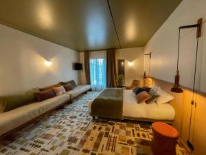 a bedroom with a large bed and a couch at Hôtel Oré, Saint-Malo in Saint Malo