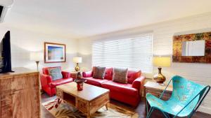 a living room with a red couch and chairs at Downtown Cozy Home Base - Purple Sage 6 in Moab