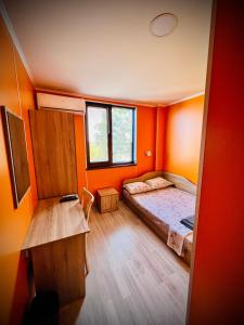 a bedroom with orange walls and a bed in it at Хижа Манастирчето-Книжовник in Haskovo