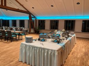 a row of tables in a large room with blue lighting at Oste-Hotel Superior in Bremervörde