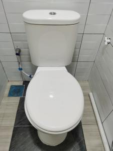 a bathroom with a white toilet in a stall at Roomstay Villa Tok Wan in Kuantan