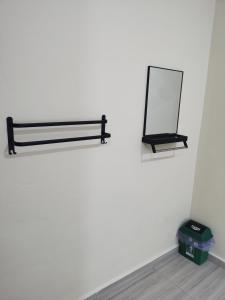 a mirror hanging on a wall next to a box at Roomstay Villa Tok Wan in Kuantan