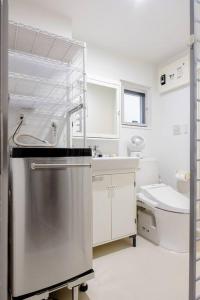 a white bathroom with a sink and a toilet at アンドステイ白金6丁目201 in Tokyo