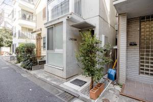 a building with a tree in front of it at アンドステイ白金6丁目201 in Tokyo