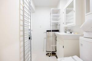 a white bathroom with a sink and a dishwasher at アンドステイ白金6丁目201 in Tokyo