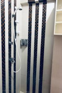 bagno con doccia a righe bianche e nere di OYO 93585 Apartemen Cibubur Village By Raja Property a Depok
