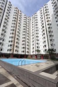 una piscina di fronte a due grandi condomini di OYO 93585 Apartemen Cibubur Village By Raja Property a Depok
