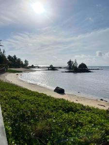 a beach with the sun shining on the water at Trou aux Biches Serenity in Pointe aux Biches
