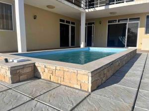 a swimming pool with a stone wall around a house at Trou aux Biches Serenity in Pointe aux Biches