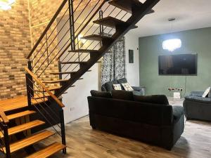 a living room with a couch and a staircase at Trou aux Biches Serenity in Pointe aux Biches