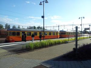 duas pessoas numa plataforma ao lado de um comboio em Kristinebergs Bed & Breakfast em Mora