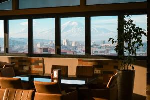 vistas a las montañas nevadas desde la ventana del restaurante en Felinger Collection Hotel & SPA, en Ereván