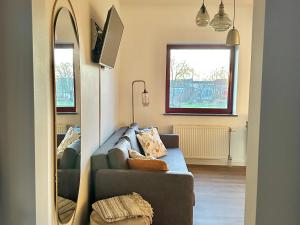 a living room with a couch and a mirror at Guesthouse De Wissen in Dilsen-Stokkem