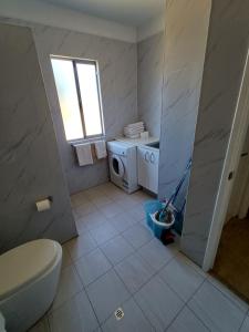 a bathroom with a toilet and a washing machine at Modern Hillside Apartments in Kelmscott