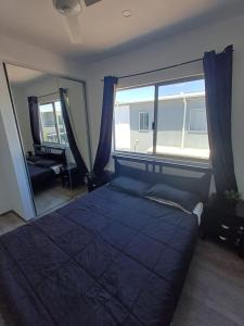 een slaapkamer met een groot bed en een groot raam bij Modern Hillside Apartments in Kelmscott