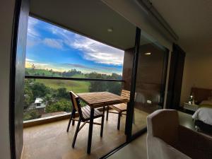 Habitación con balcón con mesa y silla. en Room in Studio - Suite hotelera - A 5 minutos del Aeropuerto, en San Antonio de Pereira