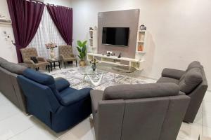 sala de estar con 2 sofás y TV en Mahligai Homstay 1Krubong 4 Rooms & Aircon In Hall, en Kampong Kerubong