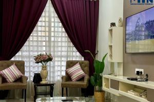 sala de estar con 2 sillas y ventana grande en Mahligai Homstay 1Krubong 4 Rooms & Aircon In Hall, en Kampong Kerubong