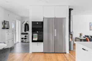a kitchen with a stainless steel refrigerator and white cabinets at Holiday home in Växjö