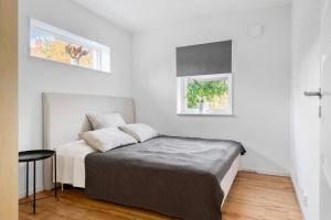 1 dormitorio blanco con 1 cama y 2 ventanas en Holiday home en Växjö