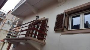 una escalera de madera en el lateral de un edificio con ventana en Φιλόξενο Σπίτι, en Nauplia