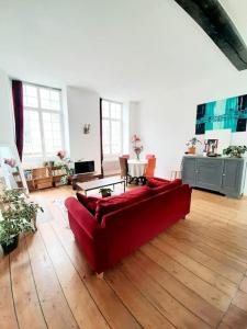 een woonkamer met een rode bank en een tafel bij Appartement XVIIIème centre historique in Bordeaux