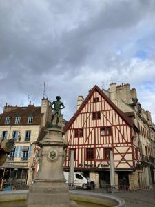 eine Statue in einem Brunnen vor einem Gebäude in der Unterkunft Studio Lumineux, Coeur De Ville in Dijon