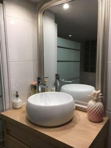 een badkamer met een grote witte wastafel en een spiegel bij Appartement XVIIIème centre historique in Bordeaux