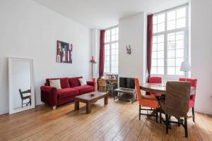 een woonkamer met een rode bank en een tafel bij Appartement XVIIIème centre historique in Bordeaux