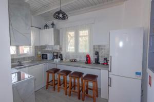 a kitchen with a white refrigerator and some bar stools at Galini Apartments Old Town in Rhodes Town
