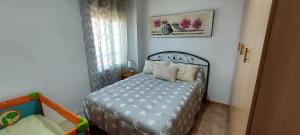 a small bedroom with a bed and a crib at Villa Adelina en Santa Pola in Santa Pola