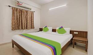a bedroom with a large bed with green pillows at The Trinitywood Hotel Restaurants in Bangalore