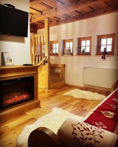 a living room with a fireplace and a tv at The Post Stana de Vale in Stana de Vale +17 photos