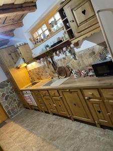 a kitchen with wooden cabinets and a cat sitting on the counter at The Post Stana de Vale in Stana de Vale