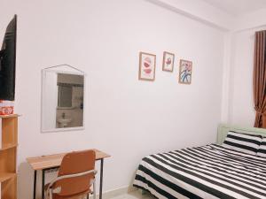 Schlafzimmer mit einem Bett, einem Schreibtisch und einem Spiegel in der Unterkunft The New House in Ấp Ða Lợi