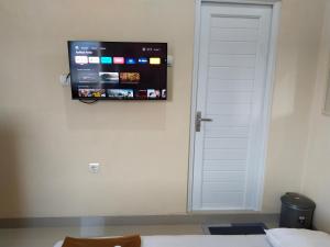 a flat screen tv on the wall of a room at U Eleven Syariah Homestay in Rawarotan