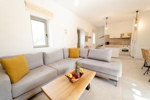 sala de estar con sofá y mesa con un bol de fruta en Villa Castillo Ena, en Agios Nikolaos